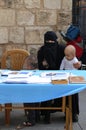 Unidentified Woman with Burka sitting with her Son