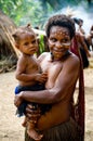 Unidentified woman with child of a Papuan tribe