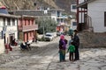 An unidentified woman with a child talking to a guy on the central street of Jomsom in Nepal, Mustang district