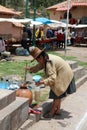 Unidentified Woman is fetching a Drink in Raqui. Peru