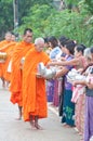 An unidentified woman Gives food to a monk