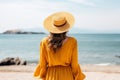 Unidentified woman leisurely savoring the warm sunrays during her delightful summer beach vacation