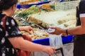 Unidentified woman at the seafood market is buying the extra large size of giant malaysian prawn (Macrobrachium rosenbergii) also