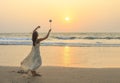 Unidentified woman spinning poi on the beach.