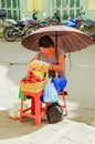 Unidentified woman under an umbrella selling a delicious chontaduro amazonian tropical fruit Bactris gasipaes in the