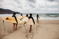 Unidentified women surfers with surfing boards coming to the sea