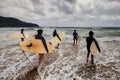 Unidentified women surfers with surfing boards coming to the sea