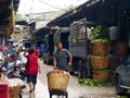 An unidentified worker pushes a cart full of vegetables through the vegetable market