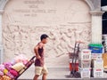 An unidentified worker pushes a cart full of vegetables through the vegetable market