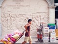 An unidentified worker pushes a cart full of vegetables through the vegetable market