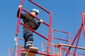 Unidentified workers setting up iron scaffolding at construction