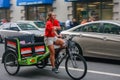 Unidentified young female trishaw driver on downtown street