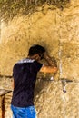 Unidentified young jewish worshiper in skullcap praying at the Wailing Wall an important jewish religious site