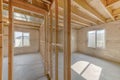 Unifinished basement interior with vapor barrier and windows with window well