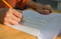 Uniform School Asian students taking exams writing answer optical form with pencil in high school classroom, view of having exams