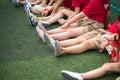 Uniformed children aligned legs sitting on grass