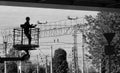 Uniformed electricians repairing electrical wires on a high pole