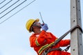 Uniformed electricians work on high-rise electricity poles along with safety equipment