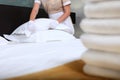 A uniformed maid changes bed linen in an expensive hotel room. Clean towels on the bed. The concept of the hotel business. Quality