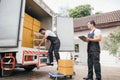 Uniformed removal company workers unload boxes and furniture from the truck Royalty Free Stock Photo