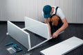 A uniformed worker collects a white metal shelving for storage in a warehouse or storeroom