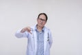 An unimpressed and dismissive doctor gives the thumbs down sign. Of asian descent, middle aged male in his 40s.