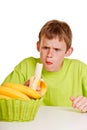 Unimpressed young boy eating a fresh banana Royalty Free Stock Photo