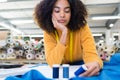 uninspired female dressmaker leaning across bench with bored expression Royalty Free Stock Photo