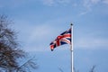 Union Jack flag against blue sky with clouds Royalty Free Stock Photo
