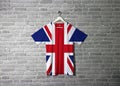 Union jack flag on shirt and hanging on the wall with brick pattern wallpaper Royalty Free Stock Photo