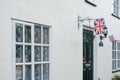 Union Jack flags seen attached to the iron-works of a large, detached cottage.