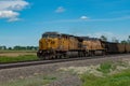 Union Pacific lashup with locomotives 6814 and 5468 smokes and steams westbound with empty coal hoppers Royalty Free Stock Photo