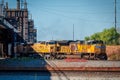 Union Pacific locomotive exiting lower bridge with plumes of black smoke