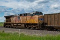 Union Pacific locomotive 8135 heads eastbound with a train with coal loaded hoppers with helper Union Pacific diesel locomotive