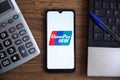 UnionPay logo displayed on smartphone on a table with calculator and notebook. Royalty Free Stock Photo