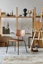 Unique artist workspace interior with stylish desk, wooden easel, bookcase, artworks, painting accessories, decoration.