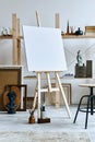 Unique artist workspace interior with wooden easel, bookcase, artworks, painting accessories, decoration and elegant personal.