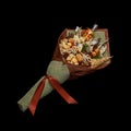 Unique bouquet consisting of dried salted fish, salted peanuts, crackers, dried bread and other beer snacks isolated on black back