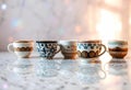 Unique Collection of Decorative Cups Arranged on a Marble Surface With Soft Sunlight Glimmering Royalty Free Stock Photo
