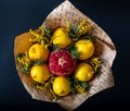Unique festive bouquet of pomegranate, lemon and memoses on a black background. Fruit bouquet. Fruits and Vegetables of the
