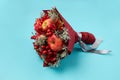 Unique gift in the form of a red bouquet of flowers and fruits on a blue background