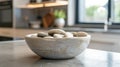 A unique handcrafted ceramic bowl filled with smooth river stones adds a touch of organic texture and minimalism to this