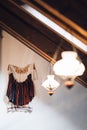 Unique hanging cloth, light fixture, and table lamp in a modern white room.