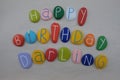 Happy Birthday Darling with colored stones over white sand Royalty Free Stock Photo