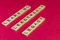 Unique high angle close up shot of words Leadership, Legacy and Learning written on wooden blocks against Pink background