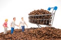 Unique image of tiny figures standing on coffee beans, a cart brimming with beans, representing collaboration in the coffee Royalty Free Stock Photo