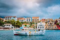 Unique majestic bay of Assos village with fishing boat at anchor in front and clouds in background, Kefalonia island Royalty Free Stock Photo