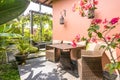 Unique patio area with wooden furniture surrounded by a garden.