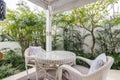 Unique patio area with wooden furniture surrounded by a garden.