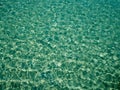 Unique perspective green crystal sea water surface ripple with sun reflection. Water background. Ocean water texture